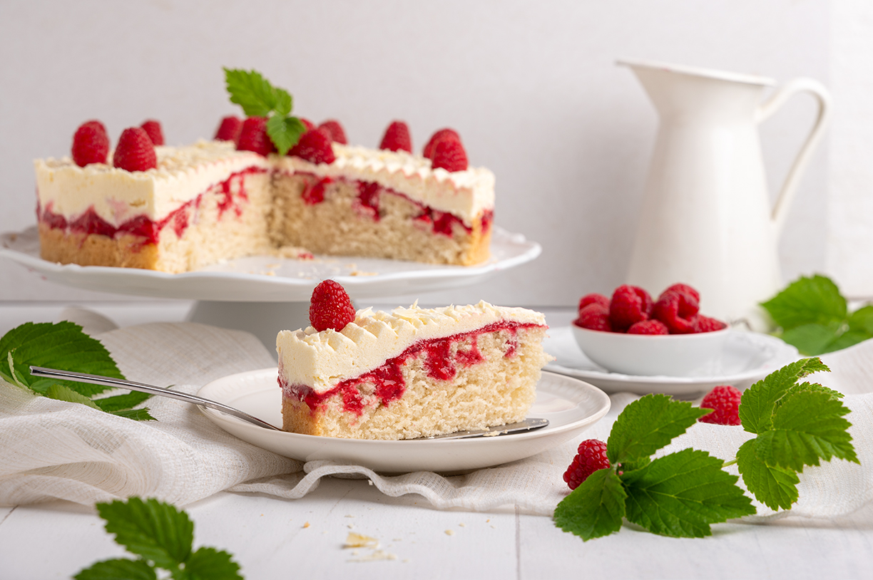 Veganer Poke Cake mit Himbeeren und Vanillepudding-Buttercreme.